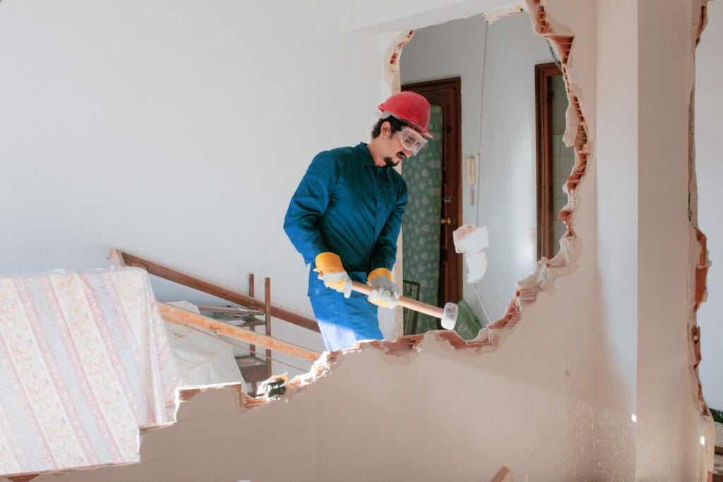 A man in the Bay Area is working on a wall that has been torn down.