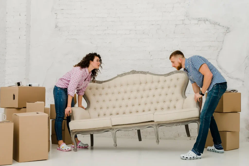 Couple moving sofa for furniture removal services.